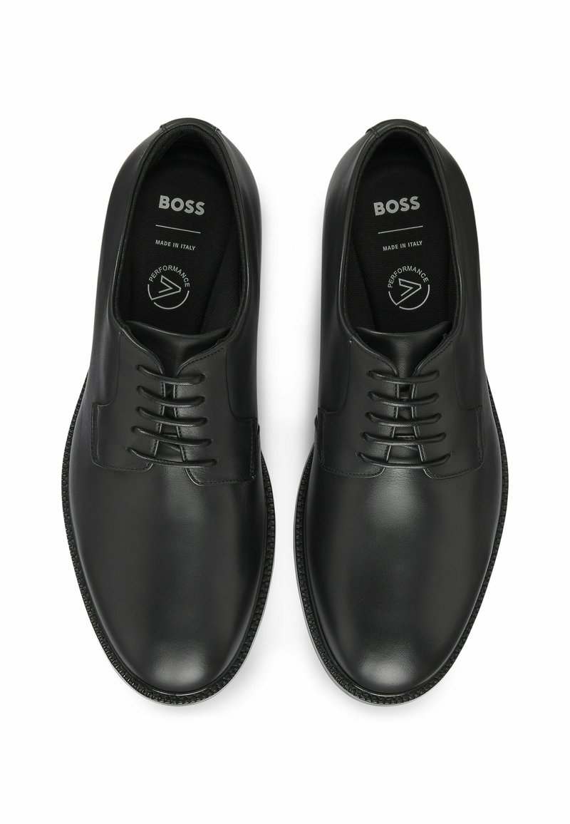 Zwarte leren schoenen met een gladde afwerking, vetersluiting, ronde neuzen en gestructureerde rubberen zolen. Merken op de binnenzolen. Gemaakt in Italië.