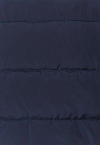 Marinblått puffjacka-material med horisontella quiltade sektioner, jämn textur och jämn sömnad. Lättviktigt med en glansig finish.