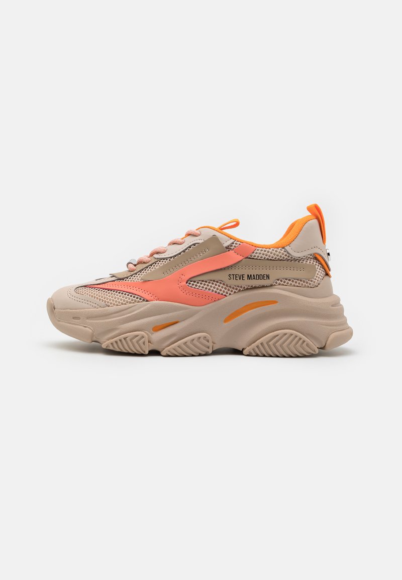 Beige sneaker with mesh and synthetic overlays, orange accents, thick sole, and pink laces. Branding displayed on the outer side.