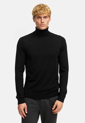 Svart polotröja med en figurnära design, rullad muddar och fåll. Tyget ser slätt och mjukt ut, vilket gör det lämpligt för lager-på-lager.