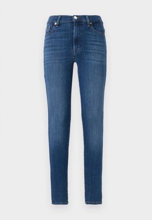 Tanki džinsi iz temno modrega denima. Imajo visok pas, sprednje žepe in subtilno zbledelost. Naravne noge z zaključnimi šivi.