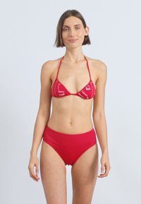 Κόκκινο μπικίνι σετ με τριγωνικό τοπ και λεπτές τιράντες, καθώς και ψηλόμεσες εσώρουχα, κατασκευασμένο από απαλό ύφασμα με μινιμαλιστικό σχέδιο.