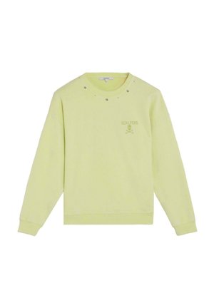 Sudadera de manga larga de color amarillo claro con cuello redondo, pequeñas decoraciones metálicas cerca del cuello y el logo de "Scalpers" con calavera y huesos cruzados en el pecho.