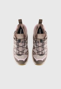Salomon sportschoenen met een lichtroze en bruine mesh bovenkant, textuuraccenten, versterkte neus en zwarte veters met een trekstrip.