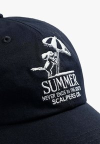 Gorra de béisbol de tela color marino con texto bordado en blanco "VERANO" y gráfico de una ardilla sosteniendo un paraguas. Cuenta con una corona estructurada y visera curvada.