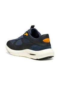 Zapatillas de deporte en color marino con acentos en negro y naranja, que cuentan con un tejido texturizado, detalles de cuero suave, una suela acolchada y un diseño aerodinámico.