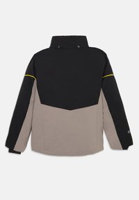 Kleurgebroken jack in zwart en beige, met een hoge kraag, drukknoopsluitingen en een gele accent langs de schoudernaad.