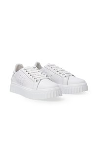 Białe sneakersy z gładką skórzaną cholewką, zaokrąglonym noskiem, sznurowanym wzornictwem, perforacjami oraz teksturowaną gumową podeszwą.