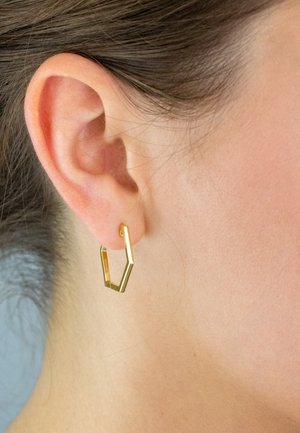 Gold geometric hoop earring with a hexagonal shape. Smooth metal finish, minimalistic design, worn on the earlobe.