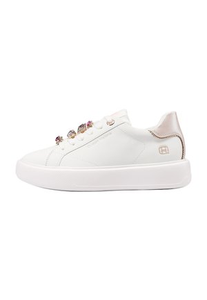 Sneaker bianca bassa con suola spessa, tallone in oro rosa metallizzato e decorazioni di perline sui lacci, su sfondo bianco semplice.