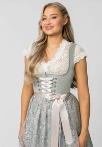 Traditional dress with a light green bodice, lace detailing, an embroidered skirt, and a satin ribbon tied at the waist.
