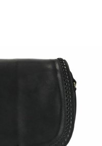 Zwarte leren crossbody tas met een gebogen vorm, textuur oppervlak en decoratieve stiksels langs de randen. Gouden hardware-details zichtbaar.