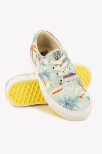 Lightweight canvas sneakers featuring a tropical floral pattern, soft beige laces, white rubber soles, and a yellow waffle-textured outsole.