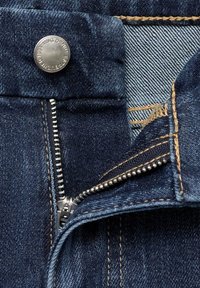 Jeans in denim blu scuro con un bottone in metallo argentato, una chiusura con cerniera e cuciture in tono chiaro. Rivestimento interno esposto con un motivo in denim più chiaro.