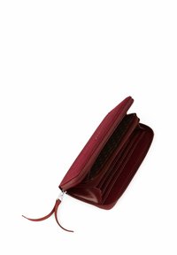 Burgundy zippered wallet with textured exterior, multiple card slots, and a polka-dot patterned lining. Accented with a smooth zipper pull.