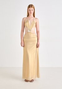 Goldener Maxikleid mit Halterneck, tiefem V-Ausschnitt, ausgeschnittenen Seiten, Raffung in der Taille und floraler Verzierung in der Mitte.