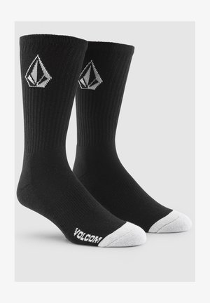 Black ribbed socks with white toe and heel accents. Features a diamond logo in white. Made from a stretchy cotton blend material.
