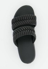 Sandales noires à glissière avec des brides tressées, semelle plate et texture lisse. Design minimaliste, adapté à un style décontracté.