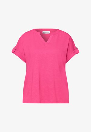 Blouse rose vif à manches courtes avec manches retroussées, pattes boutonnées et petit col en V, présentée sur fond blanc.