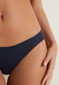 Marineblaue Bikiniunterteile aus einem weichen, dehnbaren Stoff mit niedrigem Bund und minimaler Abdeckung, ausgestattet mit glatten Kanten und einem schlichten Design.