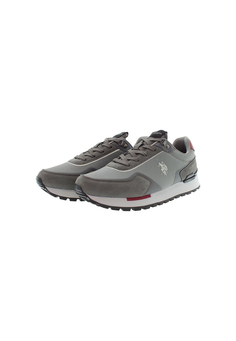Paio di scarpe sportive grigie con dettagli in suede, suole nere, lacci e una suola intermedia bianca con un logo di un giocatore di polo sul lato.