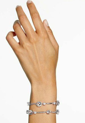 Bracelet en ton argent avec plusieurs accents en cristal circulaires, possédant une finition lisse et polie ainsi qu'un design élégant et interconnecté.