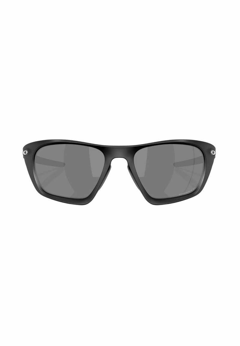 Lunettes de soleil rectangulaires noires avec verres gris, présentant une finition mate, un design de monture angulaire unique et des accents matériels minimaux aux charnières.