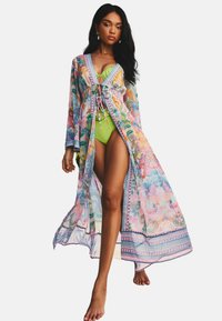 Sheer floral kimono with vibrant pink and green patterns, open front design, and long sleeves, layered over a green swimsuit.