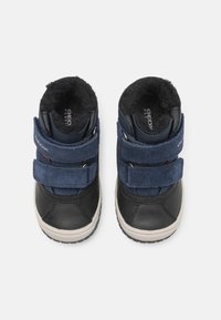 Blauwe en zwarte kinderschoenen met een bovenwerk van leer en suède, twee klittenbandsluitingen, een met bont gevoerde binnenkant en een rubberen zool.