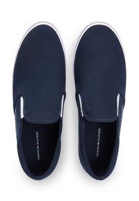 Παπούτσια navy από καμβά με λευκές σόλες από καουτσούκ. Στρογγυλεμένες μύτες και ελαστικές πλευρικές λεπτομέρειες για εύκολη εφαρμογή. Διαθέτουν λογότυπο της μάρκας στο εσωτερικό.