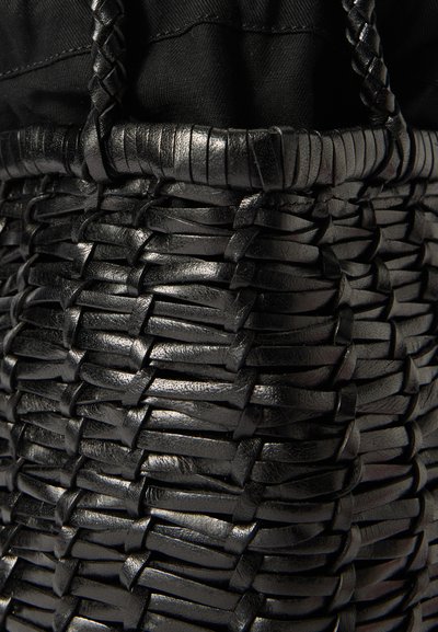 Μαύρη υφασμένη δερμάτινη τσάντα tote με υφή, λεία στοιχεία και ανθεκτικούς ιμάντες που δίνουν μια σφιχτή, δομημένη εμφάνιση.