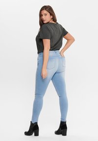 Ανοιχτό μπλε skinny jeans από τζιν, με πίσω τσέπες, φοριούνται με σκούρο γκρι μπλουζάκι και μαύρες ψηλές μπότες μέχρι τον αστράγαλο.