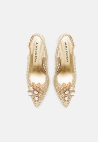 Scarpe slingback intrecciate in oro con punte appuntite, caratterizzate da un'applicazione floreale con pietre multicolori. Fodera interna liscia.