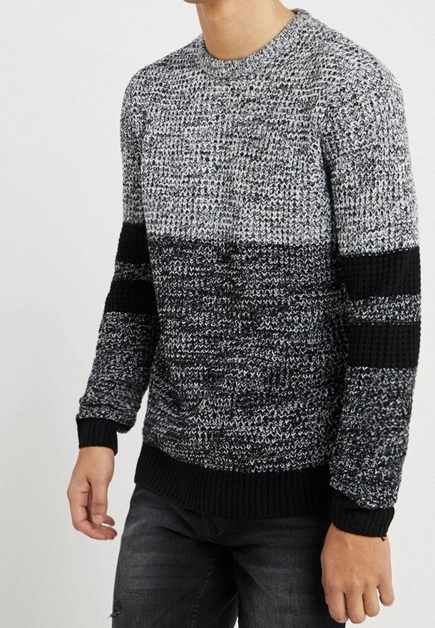 Gebreide trui in zwart en grijs met een gestructureerd patroon en contrasterende donkere strepen op de mouwen. Ronde hals en geribde manchetten.