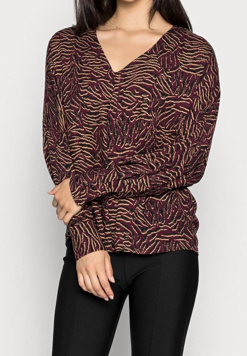Burgunderroter Pullover mit langen Ärmeln, V-Ausschnitt, strukturiertem Animal-Print in Gold und Schwarz, enganliegenden Ärmeln und weichem Stoff.