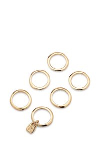 Seis pequeños anillos de oro irregulares, uno de ellos con un pequeño colgante grabado con "UNO de 50" sobre un fondo blanco.