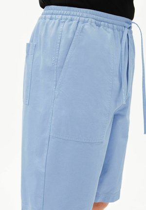 Lichtblauwe casual korte broek met elastische tailleband, zijzakken en een koord, gedragen met een zwart topje.