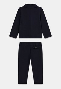 Ensemble pour enfants comprenant une veste à manches longues bleu marine avec col et un pantalon assorti avec une poche arrière.