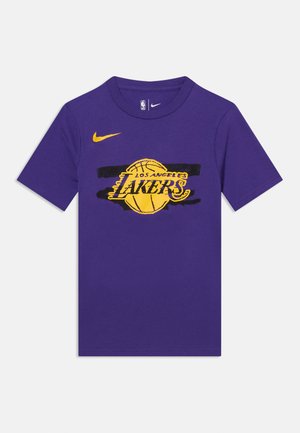 Ljubičasta majica kratkih rukava s žutim košarkaškim logom Los Angeles Lakersa i žutim Nikeovim logotipom na prednjoj strani.