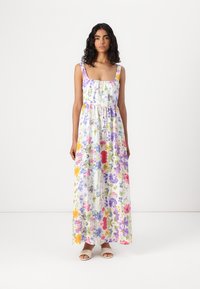 Robe maxi blanche avec un imprimé floral multicolore. Dotée de larges bretelles, d'un décolleté carré et d'une taille froncée pour une silhouette fluide.