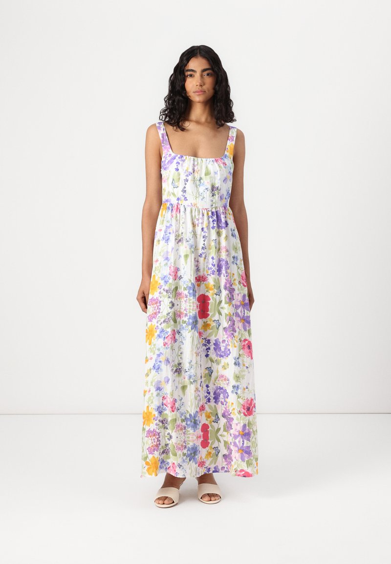 Robe maxi blanche avec un imprimé floral multicolore. Dotée de larges bretelles, d'un décolleté carré et d'une taille froncée pour une silhouette fluide.