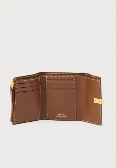 Ruskea nahkainen kolmitaitteinen lompakko kultaisella lukolla, useilla korttipaikoilla, vetoketjullisella kolikkotaskulla ja sisäpuolella Polo by Ralph Laurenin kultainen logo.