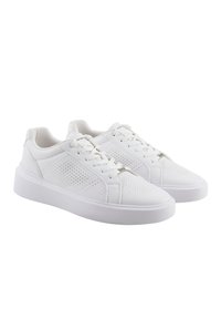 Zapatillas sintéticas blancas con un acabado liso, diseño perforado en los laterales, suelas planas blancas y cierre con cordones tradicional.