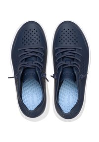 Zapatillas ligeras de color azul marino con parte superior perforada, cordones en el mismo tono y plantillas suaves de color azul. Las suelas de goma blanca completan el diseño.