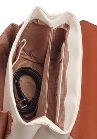 Wnętrze brązowej i białej torby na ramię zawiera dwie przegródki z beżowym wykończeniem, jedną kieszeń na zamek i czarny pasek wewnątrz.