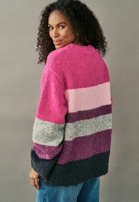Gosig, överdimensionerad tröja med horisontella ränder i rosa, lila, grå och mörk marinblå. Texturerad tyg med sänkta axlar.