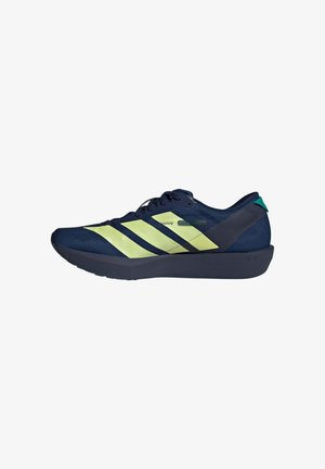 Chaussure de sport bleu marine avec bandes jaune néon, semelle noire, design à lacets et languette de talon verte, vue de côté.