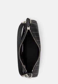 Μαύρη δερμάτινη τσάντα με χρυσές ρίγες, κλείσιμο με φερμουάρ και ασημένια αξεσουάρ. Διαθέτει εσωτερική επένδυση και αποσπώμενο λουρί. Συμπαγής, επίπεδος σχεδιασμός.