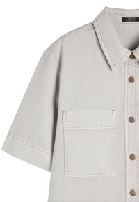 Jasnoszara koszula z krótkim rękawem wykonana z denimu, z kołnierzykiem w kształcie szpicu, brązowymi guzikami oraz kieszenią na piersi z kontrastowym przeszyciem.
