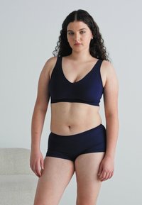 Navy blue bra and boyshort set, made of smooth fabric, featuring a v-neckline and wide straps for support. Simple design with no visible patterns.